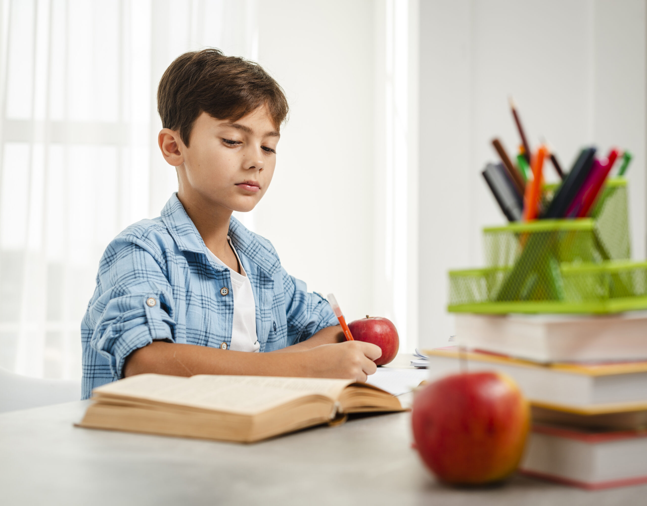 nino de angulo bajo comiendo manzana mientras estudiaba